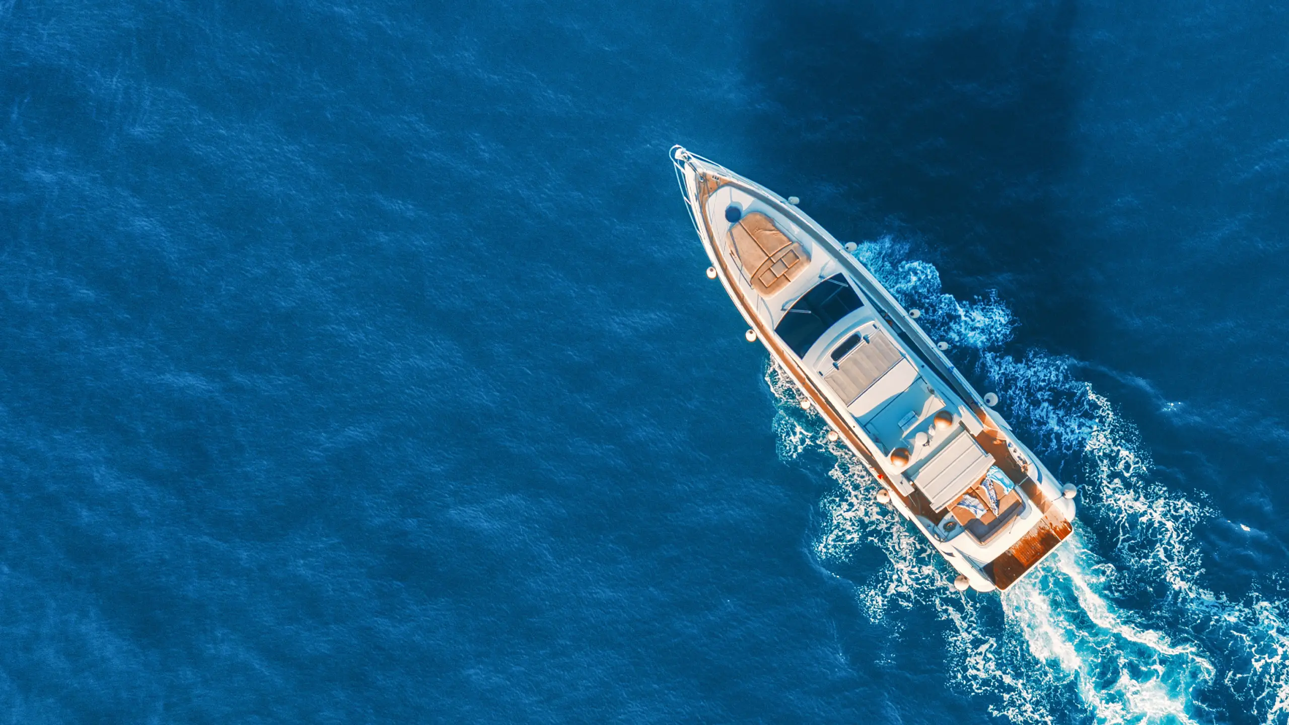 A luxury yacht anchored in a tranquil bay at sunset